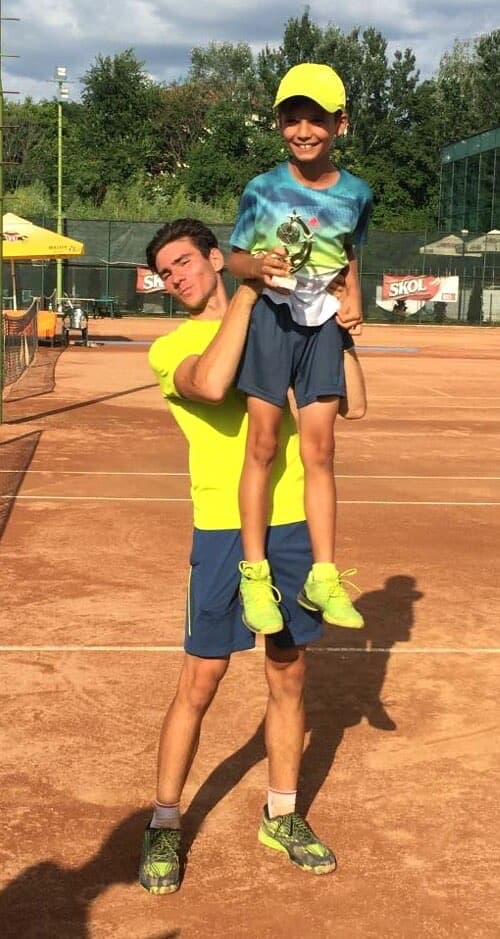 Junger Tennisspieler mit Pokal